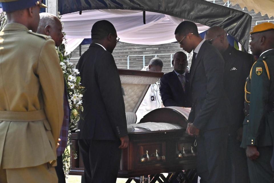 Mugabe's son Robert Junior looks into the casket bearing his father's remains (AFP/Getty Images)