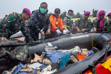 Soldiers drag an inflatable raft as they carry debris of the Lion Air flight JT610 airplane that crashed into the sea, as they walk at Tanjung Pakis beach in Karawang, Indonesia, October 30, 2018. Antara Foto/Ibnu Chazar via REUTERS