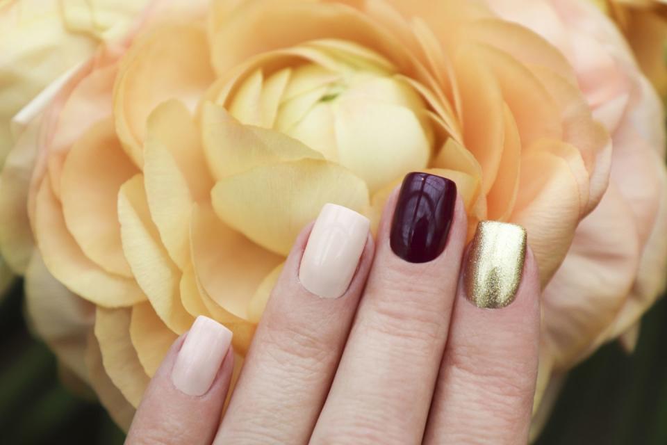 <p>Pick three colors for this manicure: one neutral polish, one bold red or burgundy, and one shiny gold. </p>