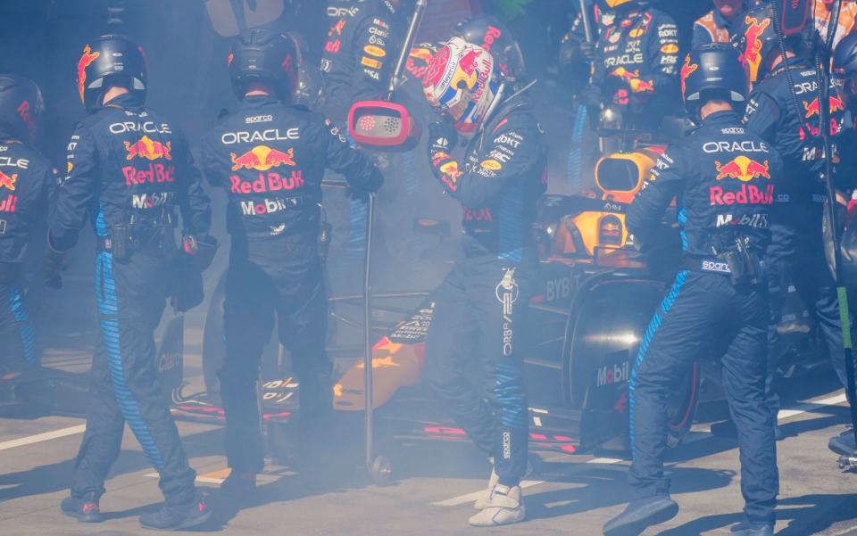 Mechanics work to extinguish a fire in Red Bull driver Max Verstappen of the Netherlands' car during the Australian Formula One Grand Prix at Albert Park, in Melbourne, Australia, Sunday, March 24, 2024