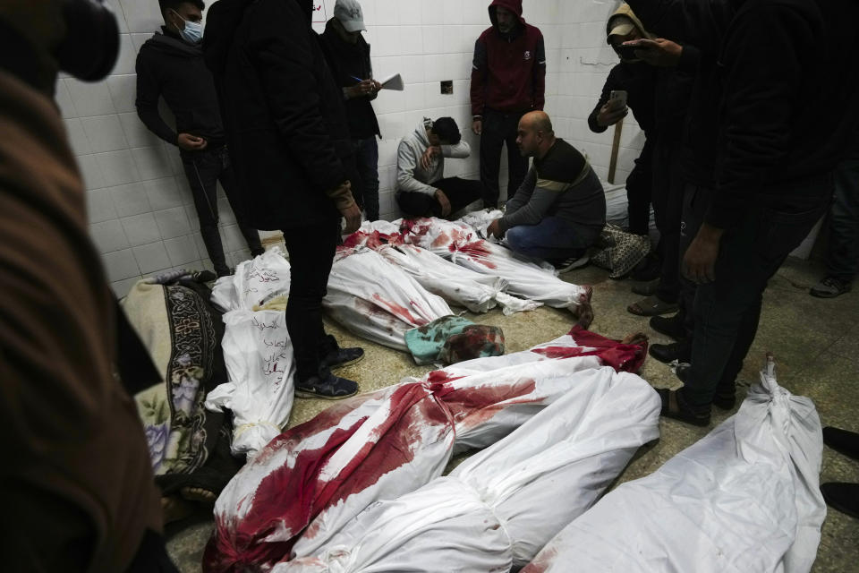 Relatives stand around the bodies of Palestinians killed in the Israeli bombing of the Nusseirat refugee camp in the Gaza Strip at Al Aqsa hospital in Deir al Balah on Sunday, Feb. 11, 2024. (AP Photo/Adel Hana)