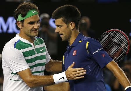 Serbia's Novak Djokovic (R) and Switzerland's Roger Federer shake hands at the net after Djokovic won their semi-final match at the Australian Open tennis tournament at Melbourne Park, Australia, January 28, 2016. REUTERS/Tyrone Siu