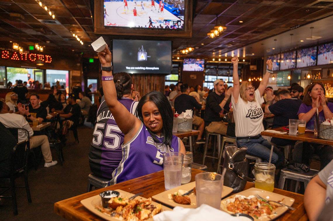 Sacramento Kings fan Brittnay Lewis, center, rings a cowbell after a Kings basket as fans gathered to watch the play-in game between the Sacramento Kings and the New Orleans Pelicans at Sauced in downtown Sacramento on Friday.