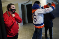 A new Jersey Devils fan reacts as she sees the ice for the first time as New. York Islanders fan snaps a cell phone photo before an NHL hockey game between the New Jersey Devils and the New York Islanders, Tuesday, March 2, 2021, in Newark, N.J. It was the first time fans were allowed in the Prudential Center under New Jersey's more relaxed COVID-19 rules. (AP Photo/Kathy Willens)