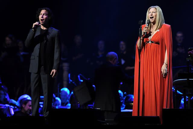 <p>Dave J Hogan/Getty</p> Jason Gould and Barbra Streisand performing onstage in London in 2013