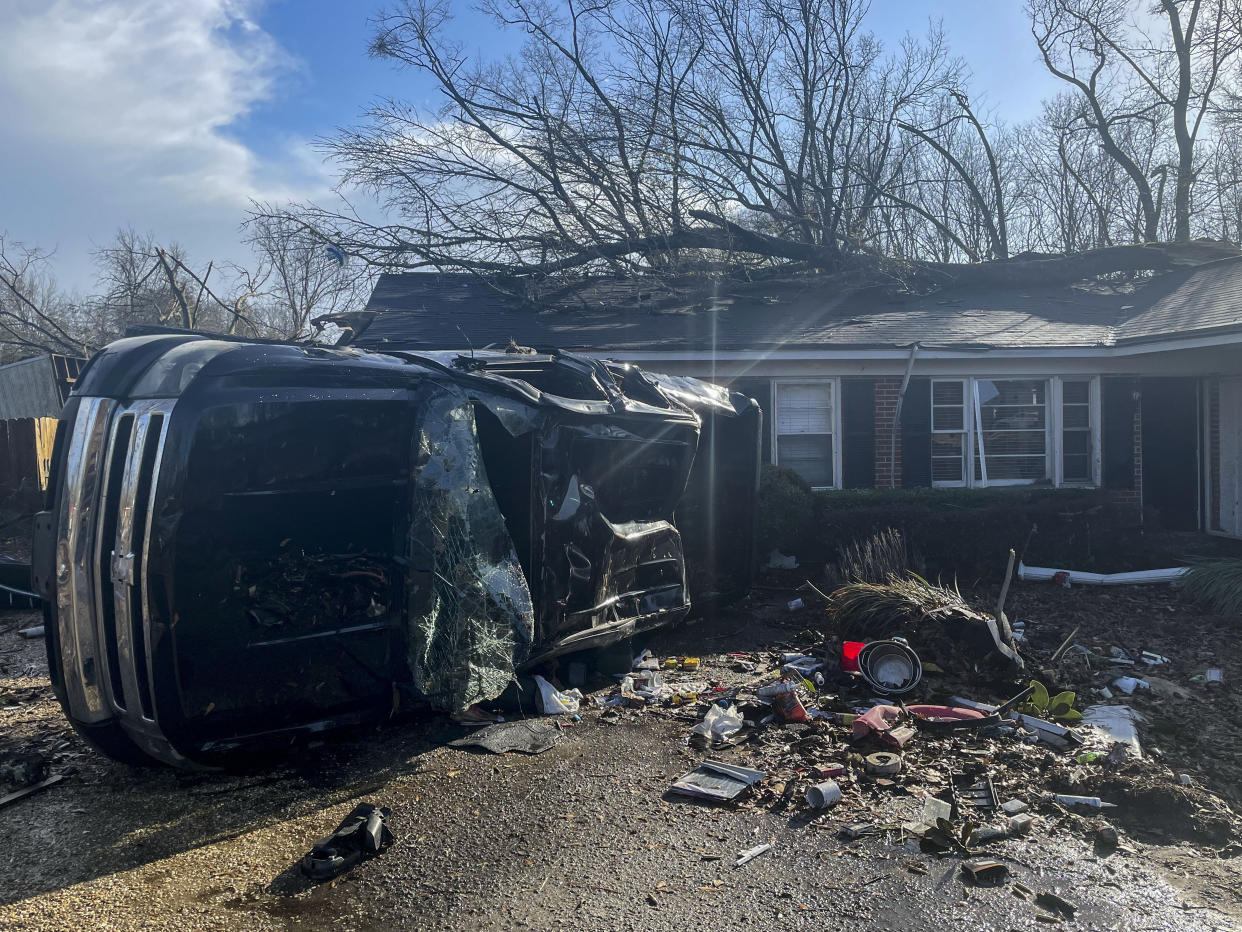A damaged vehicle rests on its side in front of a home, Thursday, Jan. 12, 2023, in Selma, Ala. A large tornado damaged homes and uprooted trees in Alabama on Thursday as a powerful storm system pushed through the South. (AP Photo/Butch Dill)
