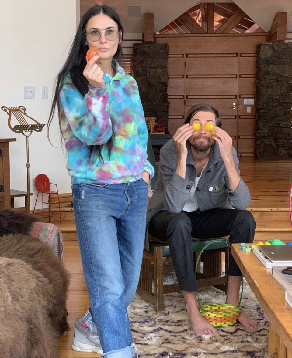 Demi Moore poses in front of tiny, spindly red chair