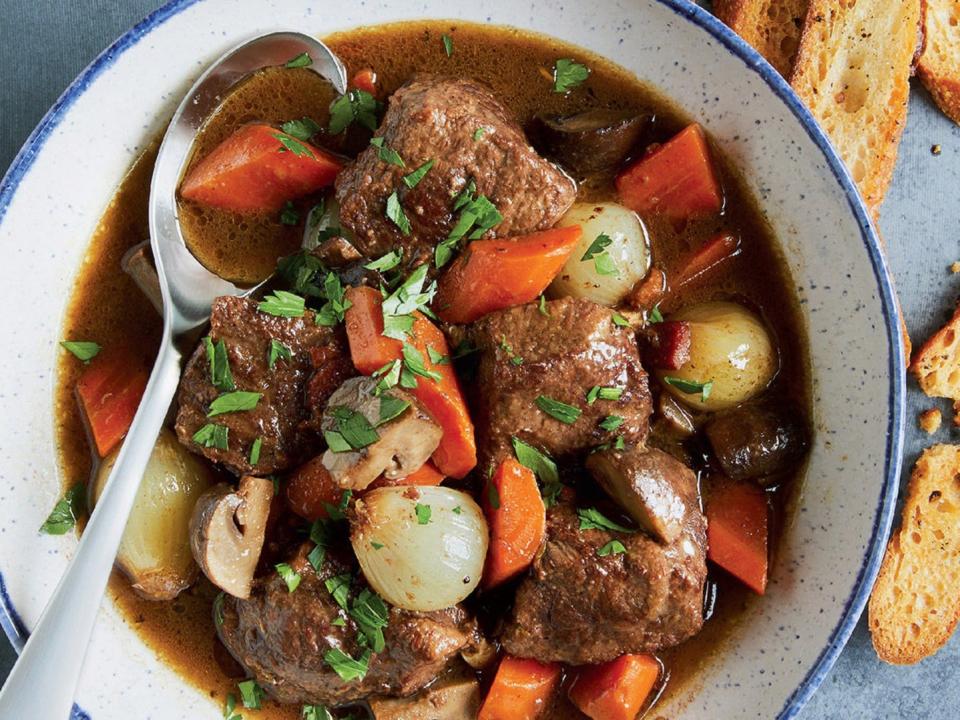 beef stew in a white bowl with a spoon