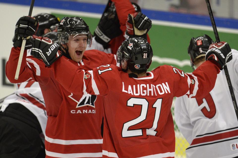 Canada's Griffin Reinhart, left, and Scott Laughton (21) celebrate Canada's first goal during first period action in a quarterfinal match at the world junior hockey tournament in Malmo, Sweden, Thursday, Jan 2, 2014. (AP Photo/The Canadian Press, Frank Gunn)