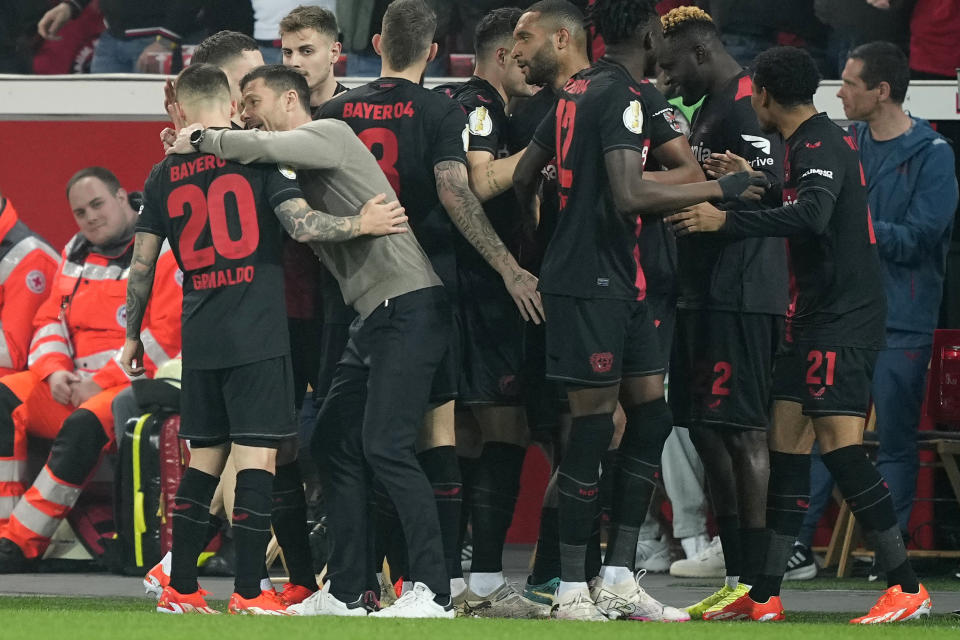 Leverkusen's head coach Xabi Alonso instructs Leverkusen's Alex Grimaldo after Leverkusen's Jeremie Frimpong scored his side's opening goal during the German soccer cup match between Bayer 04 Leverkusen and Fortuna Duesseldorf in Leverkusen, Germany, April 3, 2024. (AP Photo/Martin Meissner)