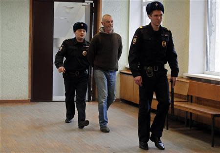 Greenpeace activist David John Haussmann (C) of New Zealand, one of 30 people arrested over a Greenpeace protest at the Prirazlomnaya oil rig, is escorted inside a court building in St. Petersburg, November 19, 2013. REUTERS/Alexander Demianchuk