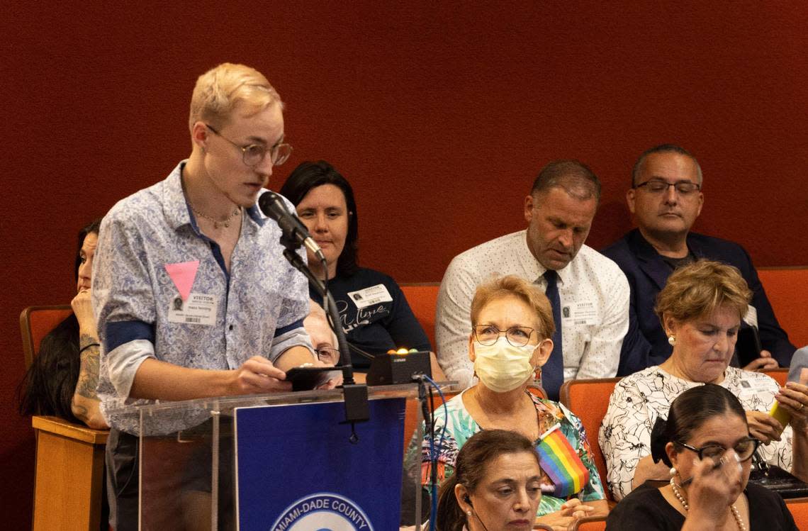 A woman looks up at Maxx Fenning while he speaks in support of the Miami-Dade School Board designating October as LGBTQ+ History Month. Fenning, president and founder of PRISM FL, a nonprofit organization that provides sexual health information to LGBTQ+ youth, wore a pink triangle as he likened opposition to the measure to how Nazis ostracized gay people, making them wear a pink triangle badge to reflect their sexual orientation.