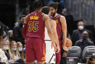 Cleveland Cavaliers guard Ricky Rubio, back, argues with Denver Nuggets guard Facundo Campazzo, center, as Cavaliers forward Isaac Okoro (35)comes in to separate the players in the second half of an NBA basketball game Monday, Oct. 25, 2021, in Denver. (AP Photo/David Zalubowski)