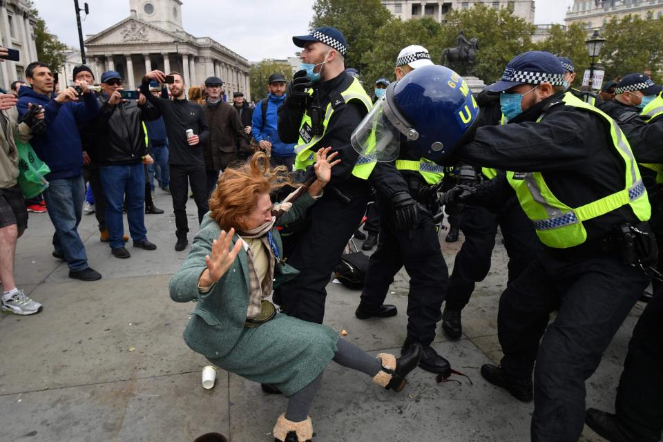 A woman falls to the ground as police try to break up the rally (AFP via Getty Images)