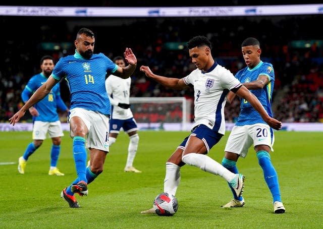 Ollie Watkins crosses under pressure from Brazil’s Fabricio Bruno and Savio