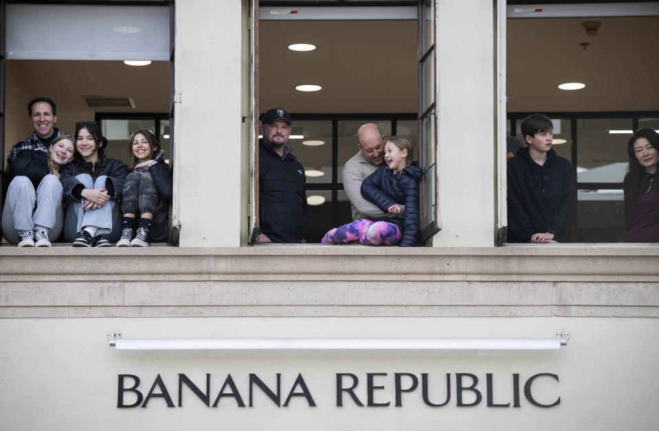 People watch the 134th Rose Parade above Banana Republic along Colorado Boulevard in Pasadena, Calif., Monday, Jan. 2, 2023. (Sarah Reingewirtz/The Orange County Register via AP)