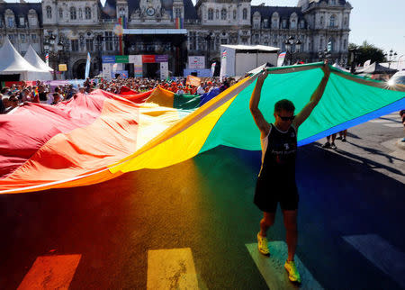 People display a huge rainbow flag as they participate at the international Rainbow Memorial Run during the inauguration of the Gay Games village at the Hotel de Ville city hall in Paris, France, August 4, 2018. REUTERS/Regis Duvignau