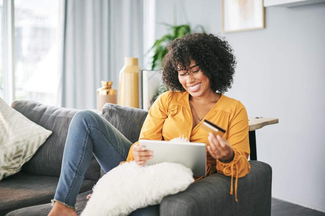 Cropped shot of an attractive young woman sitting on her sofa at home and using her tablet for online shopping