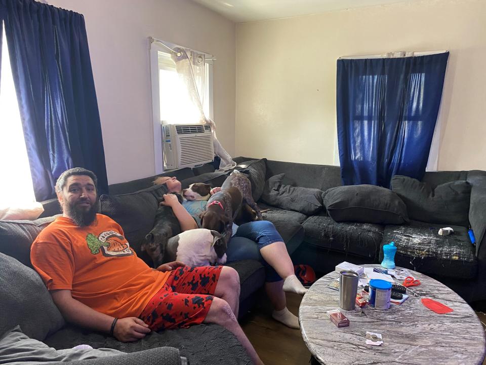 Michael Olar, left, and Renee Booher sit with their four family dogs, which the Humane Society of Richland County has returned to them. Dozens of dogs were seized Saturday from their 1024 Burger Ave. home. Olar said he had rescued the dogs from Richland County puppy mills to give to rescue groups to find them homes.