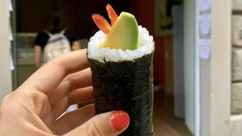hand holding sushi roll
