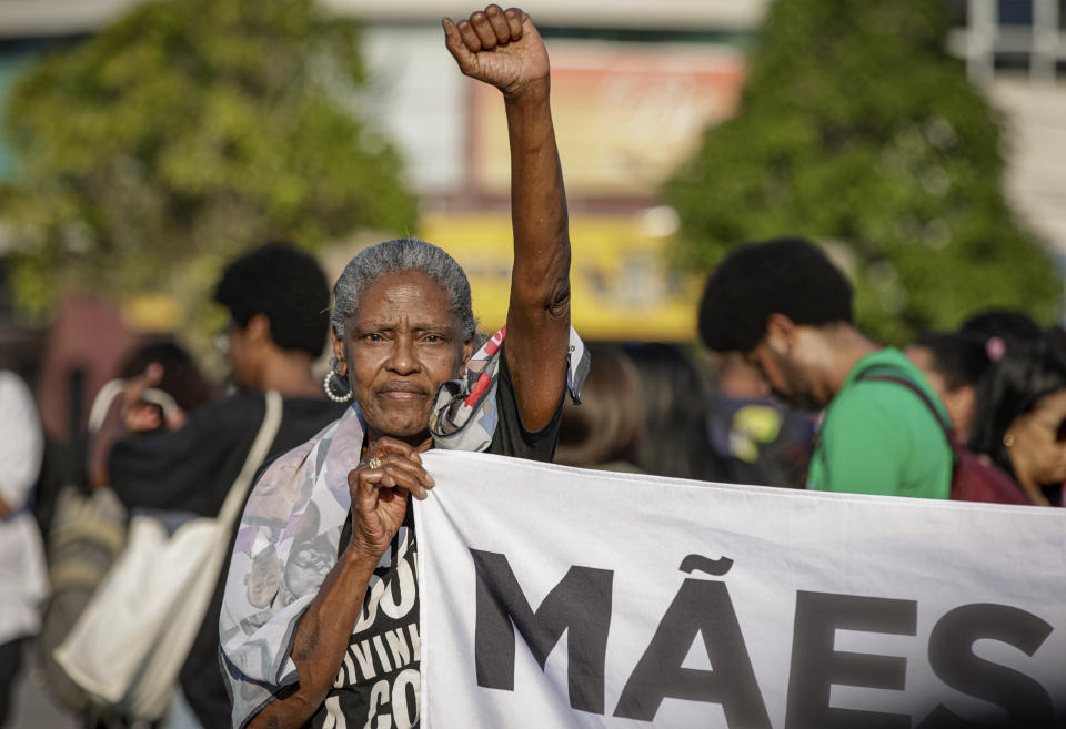 A woman holds a banner that reads "Mothers," as she protests against a police raid that killed more than a dozen of people in Guaruja, Sao Paulo state, Brazil, Wednesday, Aug. 2, 2023. The death toll from the raid has climbed to at least 14, in a sprawling operation that has raised questions about the use of lethal force by police. (AP Photo/Tuane Fernandes)