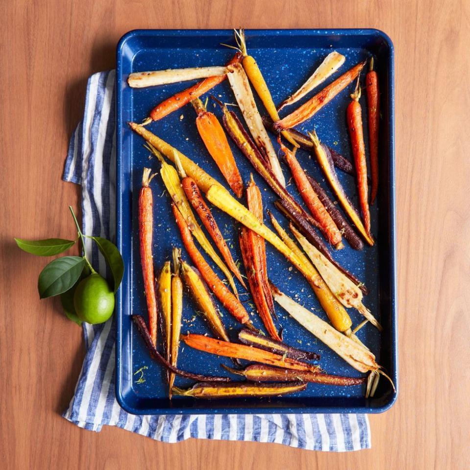 coriander maple glazed carrots on a blue baking pan