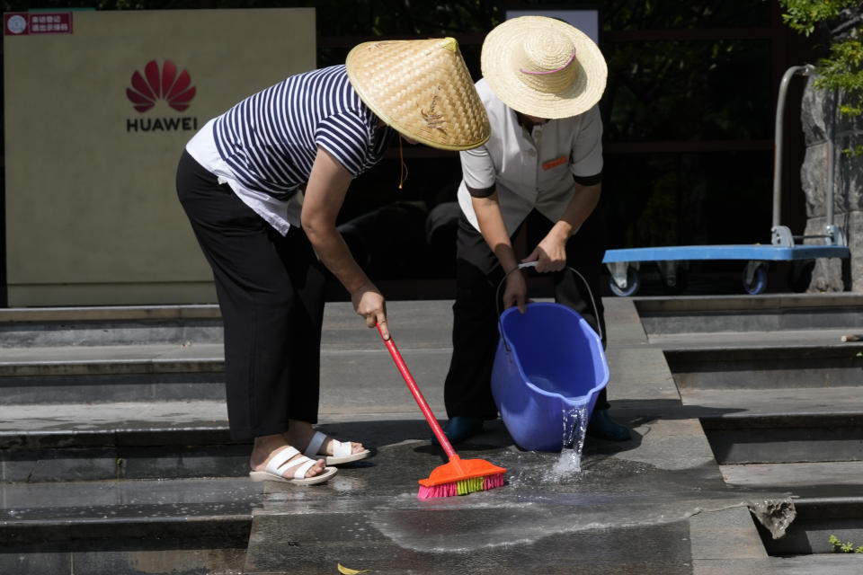 Workers wash the steps outside an entrance to the sprawling Huawei headquarters campus in Shenzhen, China, Saturday, Sept. 25, 2021. Two Canadians detained in China on spying charges were released from prison and flown out of the country on Friday, Prime Minister Justin Trudeau said, just after a top executive of Chinese communications giant Huawei Technologies reached a deal with the U.S. Justice Department over fraud charges and flew to China. (AP Photo/Ng Han Guan)