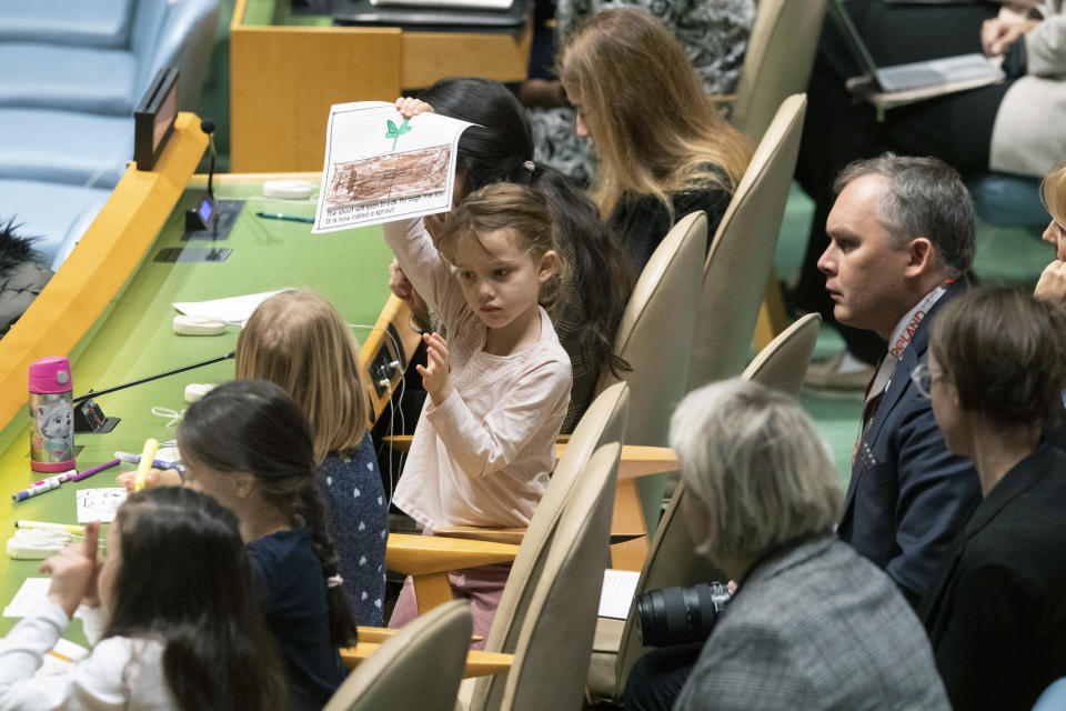 A young member of the Polish delegation shows off a drawing she made during the 30th anniversary of the adoption of the Convention on the Rights of the Child, Wednesday, Nov. 20, 2019, at United Nations headquarters. (AP Photo/Mary Altaffer)