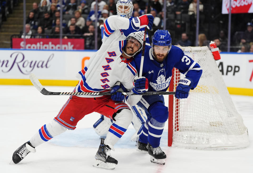 New York Rangers' Vincent Trocheck, left, and Toronto Maple Leafs' Timothy Liljegren (37) battle during the third period of an NHL hockey game in Toronto on Saturday, March 2, 2024. (Frank Gunn/The Canadian Press via AP)