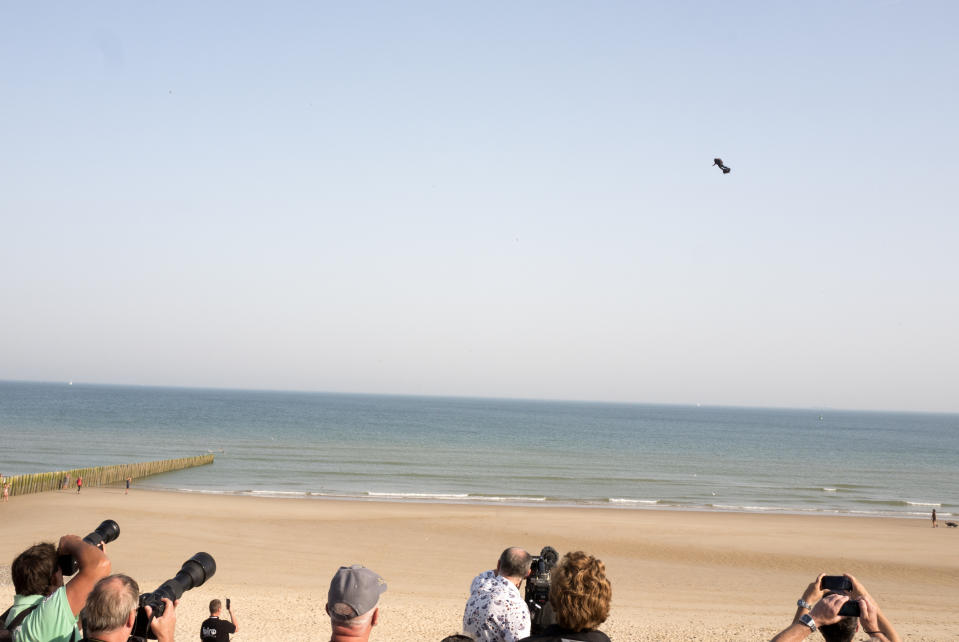 People watch as Franky Zapata, a 40-year-old inventor, takes to the air in Sangatte, Northern France, at the start of his attempt to cross the channel from France to England Thursday July 25, 2019. Zapata is anchored to his flyboard, a small flying platform he invented, taking off from Sangatte, in France's Pas de Calais region, and flying to the Dover area in southeast England. (AP Photo/Michel Spingler)