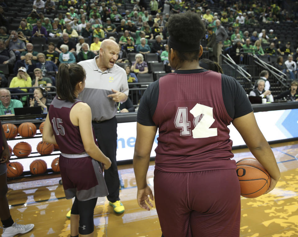 Oregon head coach Kelly Graves talks to Texas Southern players before an NCAA college basketball game in Eugene, Ore., Saturday, Nov. 16, 2019. Texas Southern's uniforms went missing, forcing them to improvise with practice jerseys and athletic tape. (AP Photo/Chris Pietsch)