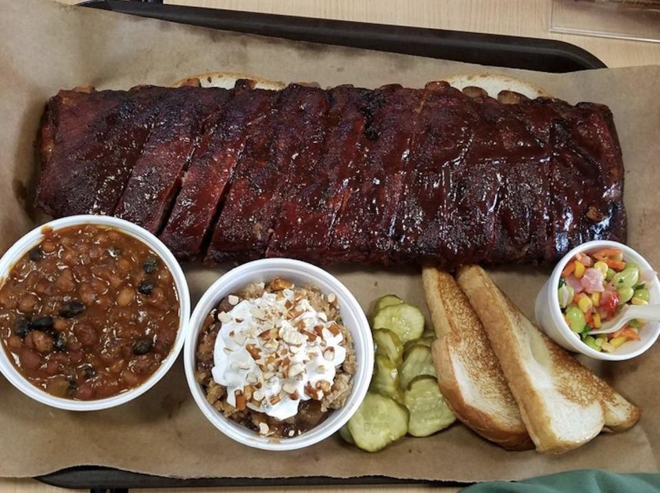 Joe's Kansas City Barbecue ribs, pickles, and sides on a tray