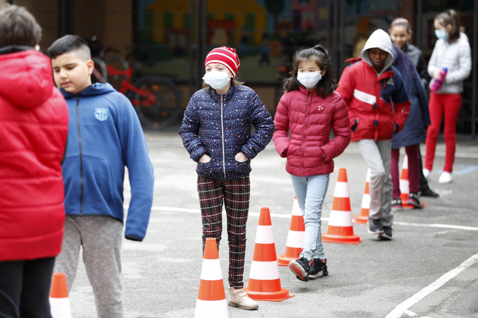 Schoolchildren wait in line to use the toilet in the schoolyard of the Sainte Aurelie primary school of Strasbourg, eastern France, Thursday, May 14, 2020. The government has allowed parents to keep children at home amid fears prompted by the COVID-19, as France is one of the hardest-hit countries in the world. Authorities say 86% of preschools and primary schools are reopening this week. (AP Photo/Jean-Francois Badias)