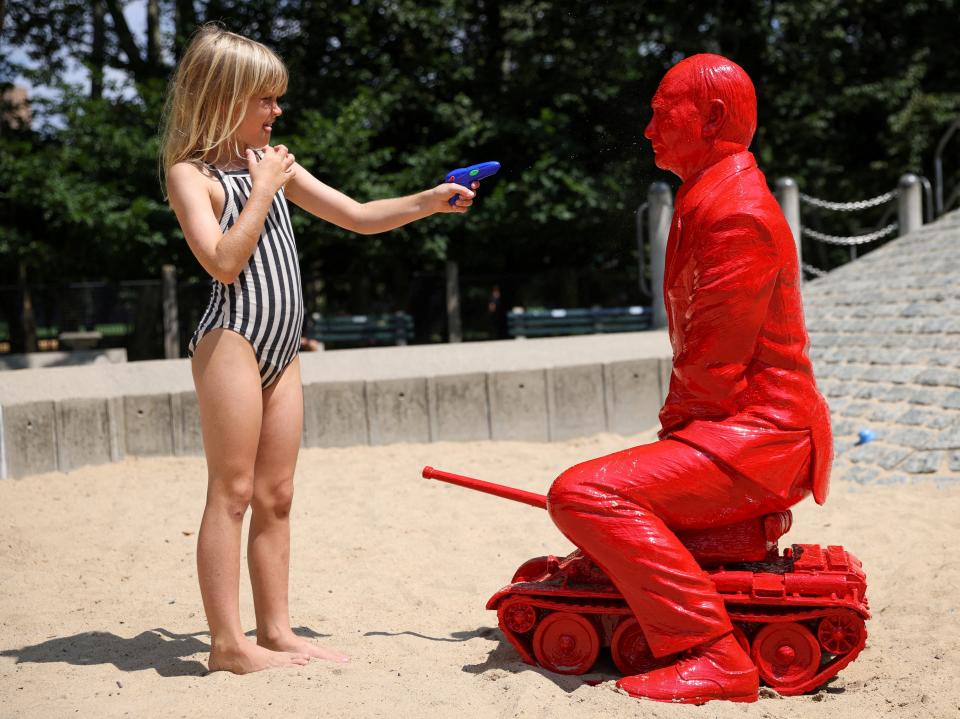 A child points a water pistol at a statue of Russian President Vladimir Putin riding a tank by French artist James Colomina in a playground in Central Park in Manhattan, New York City, U.S., August 2, 2022.