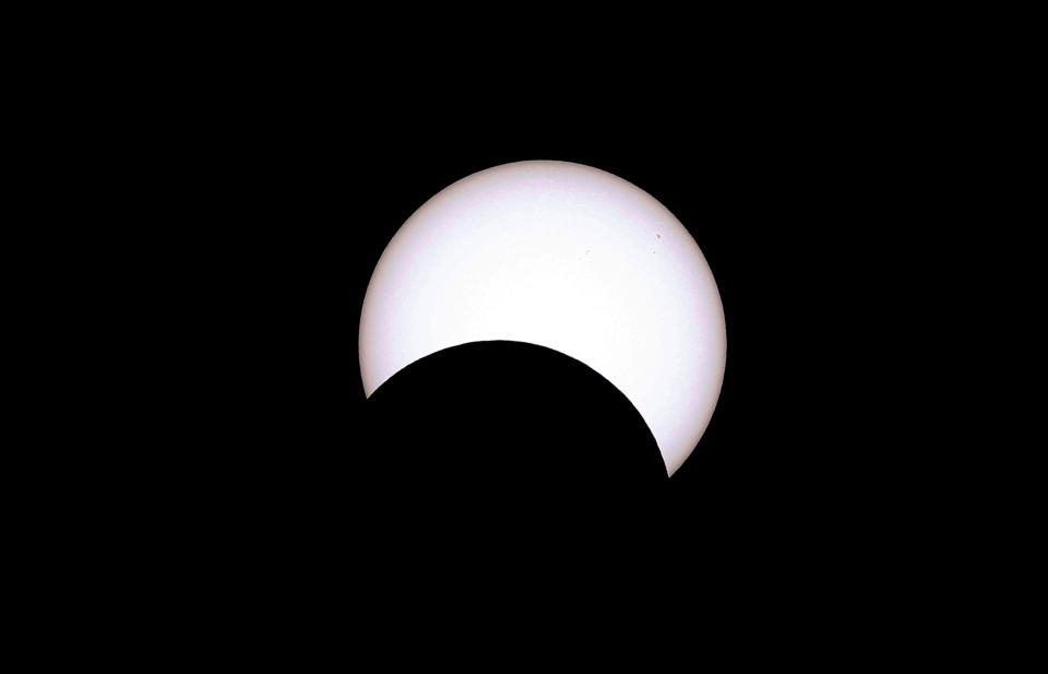 The moon crosses the sun as it exits the maximum eclipse during the Annular Solar Eclipse in Capitol Reef National Park, Utah.  / Credit: George Frey / Getty Images