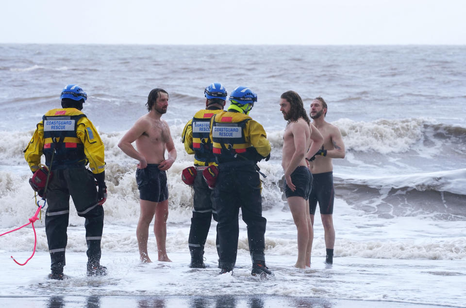 A coastguard search and rescue team ask a group of swimmers to come out of the sea in New Brighton, Merseyside, as Storm Eunice hits the south coast, with attractions closing, travel disruption and a major incident declared in some areas, meaning people are warned to stay indoors. A rare red weather warning - the highest alert, meaning a high impact is very likely - has been issued by the Met Office due to the combination of high tides, strong winds and storm surge. Picture date: Friday February 18, 2022.