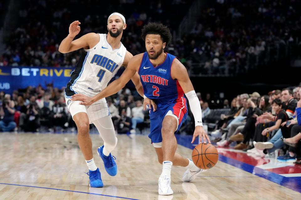 Detroit Pistons guard Cade Cunningham (2) brings the ball up court as Orlando Magic guard Jalen Suggs (4) defends at Little Caesars Arena in Detroit on Saturday, Feb. 24, 2024.
