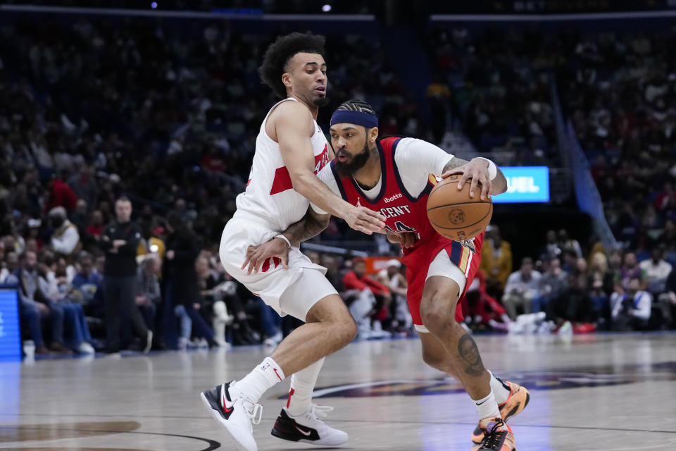 New Orleans Pelicans forward Brandon Ingram (14) drives to the basket against Toronto Raptors forward Jordan Nwora in the second half of an NBA basketball game in New Orleans, Monday, Feb. 5, 2024. The Pelicans won 138-100. (AP Photo/Gerald Herbert)