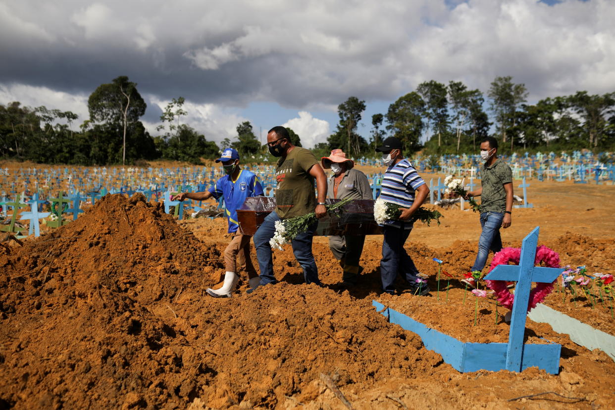 Sons of Veronica Ferreira, 73, who passed away due to the coronavirus disease (COVID-19), attend her burial at the Parque Taruma cemetery in Manaus, Brazil, December 31, 2020. REUTERS/Bruno Kelly     TPX IMAGES OF THE DAY