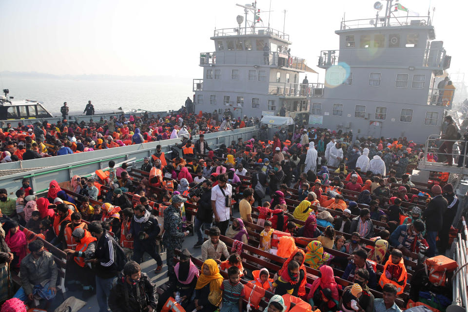 Rohingya refugees settle on to naval ships to be transported to an isolated island in the Bay of Bengal, in Chittagong, Bangladesh, Tuesday, Dec. 29, 2020. Officials in Bangladesh sent a second group of Rohingya refugees to the island on Monday despite calls by human rights groups for a halt to the process. The Prime Minister’s Office said in a statement that more than 1,500 Rohingya refugees left Cox’s Bazar voluntarily under government management. Authorities say the refugees were selected for relocation based on their willingness, and that no pressure was applied on them. But several human rights and activist groups say some refugees have been forced to go to the island, located 21 miles (34 kilometers) from the mainland. (AP Photo/Mahmud Hossain Opu)