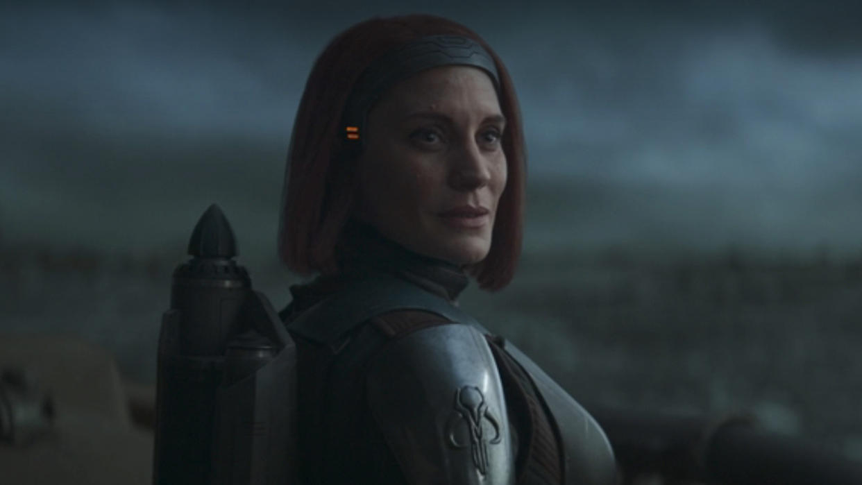  Katee Sackhoff's Bo-Katan smiling as Din Djarin walks away on The Mandalorian. 