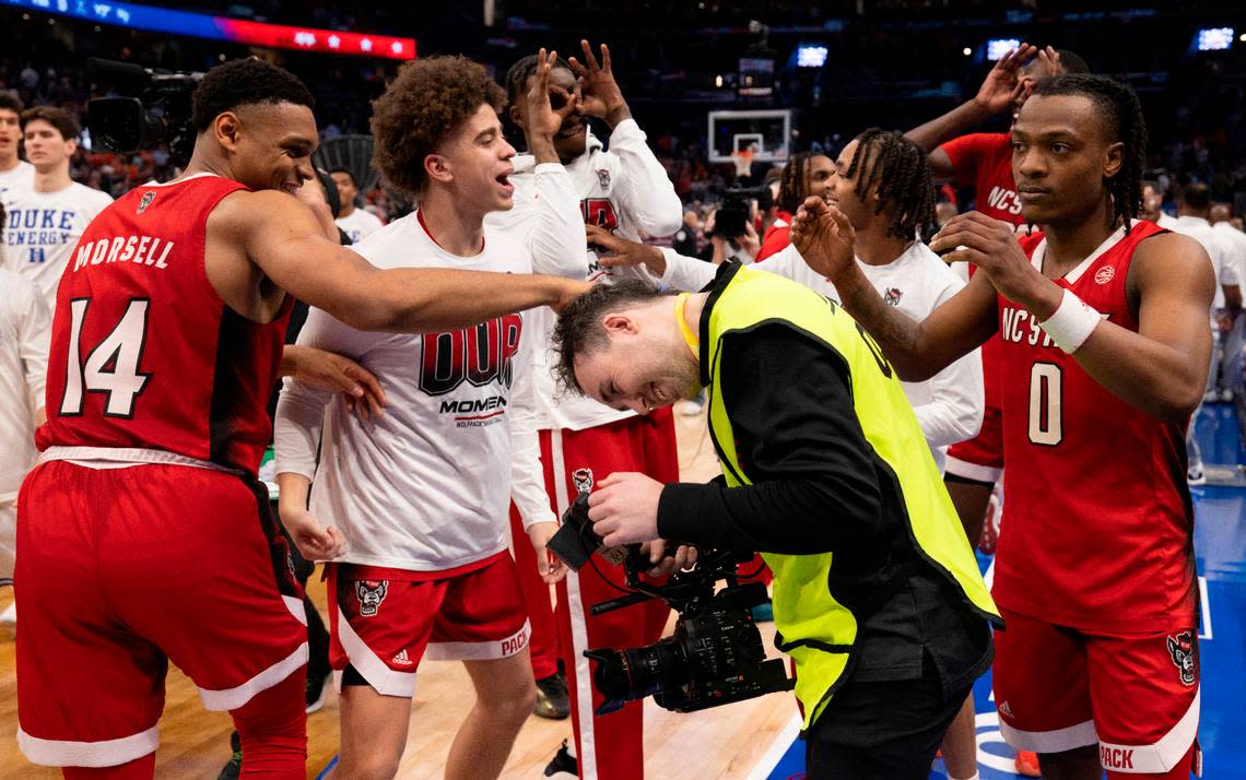 N.C. State’s D.J. Horne (0) and Casey Morsell (14) celebrate their 74-69 victory over Duke with videographer Roland DesLauriers in the quarterfinals of the ACC Men’s Basketball Tournament at Capitol One Arena on Wednesday, March 13, 2024 in Washington, D.C.