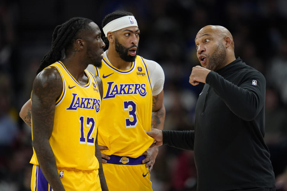 Los Angeles Lakers coach Darvin Ham talks with forwards Taurean Prince (12) and Anthony Davis (3) during the first half of the team's NBA basketball game against the Minnesota Timberwolves, Thursday, Dec. 21, 2023, in Minneapolis. (AP Photo/Abbie Parr)