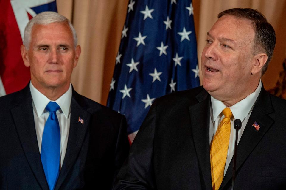 Secretary of State Mike Pompeo, right, gives a speech as Vice President Mike Pence looks on during a luncheon at the State Department in Washington, D.C., on Sept. 20, 2019.