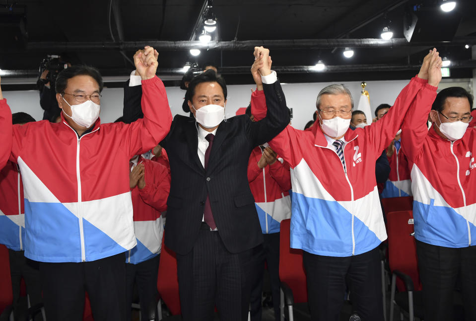 Oh Se-hoon, candidate of the main opposition People Power Party, celebrates with party members while watch monitors broadcasting the results of exit polls for the Seoul mayoral by-election at the party's headquarters Wednesday, April 7, 2021, in Seoul, South Korea. (Song Kyung-seok/Pool Photo via AP)