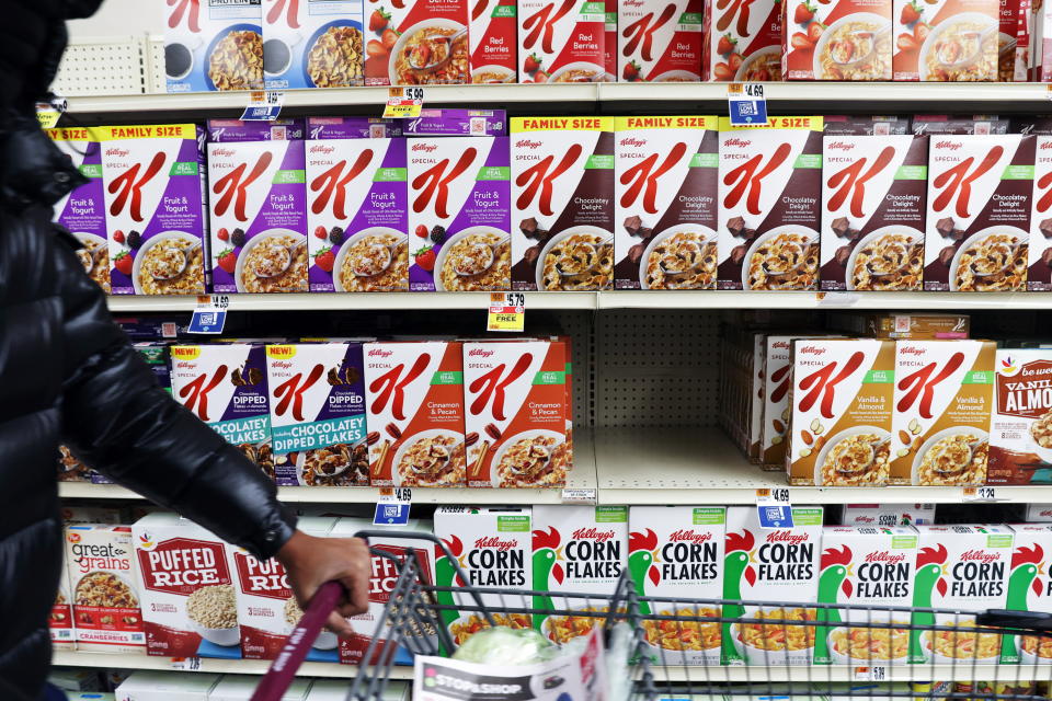 Una persona cammina davanti a una mostra di cereali Kellogg, di proprietà di Kellogg Company, in un negozio nel Queens, New York City, USA, 7 febbraio 2022. REUTERS/Andrew Kelly