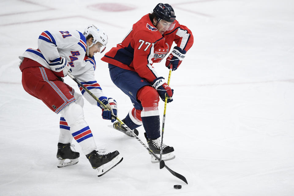 Washington Capitals right wing T.J. Oshie (77) and New York Rangers center Brett Howden (21) battle for the puck during the second period of an NHL hockey game, Saturday, Feb. 20, 2021, in Washington. (AP Photo/Nick Wass)