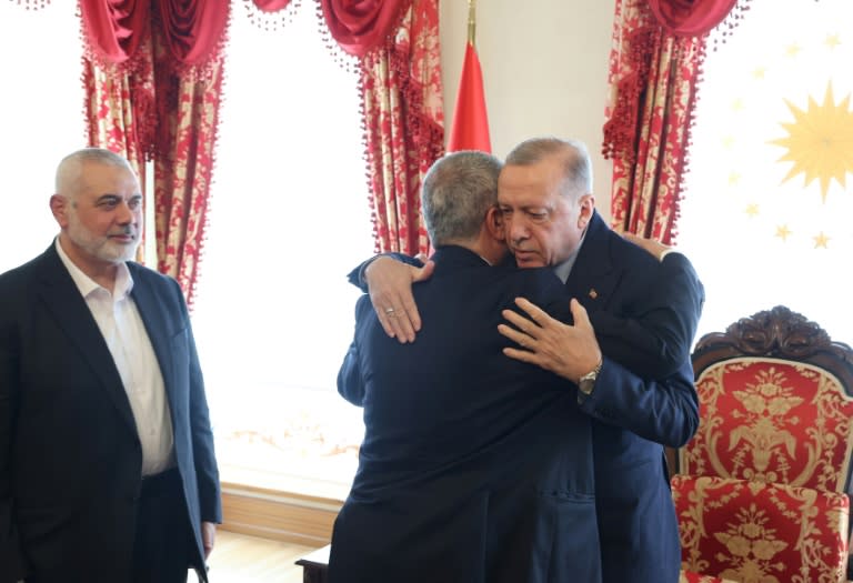 Photo transmise par la présidence turque le 20 avril 2024 montrant le président turc Recep Tayyip Erdogan (D) donnant l'accolade à Khaled Mechaal, l'un des principaux dirigeants du Hamas, lors d'une rencontre avec le chef du Hamas, Ismaïl Haniyeh (G)à Istanbul (Handout)