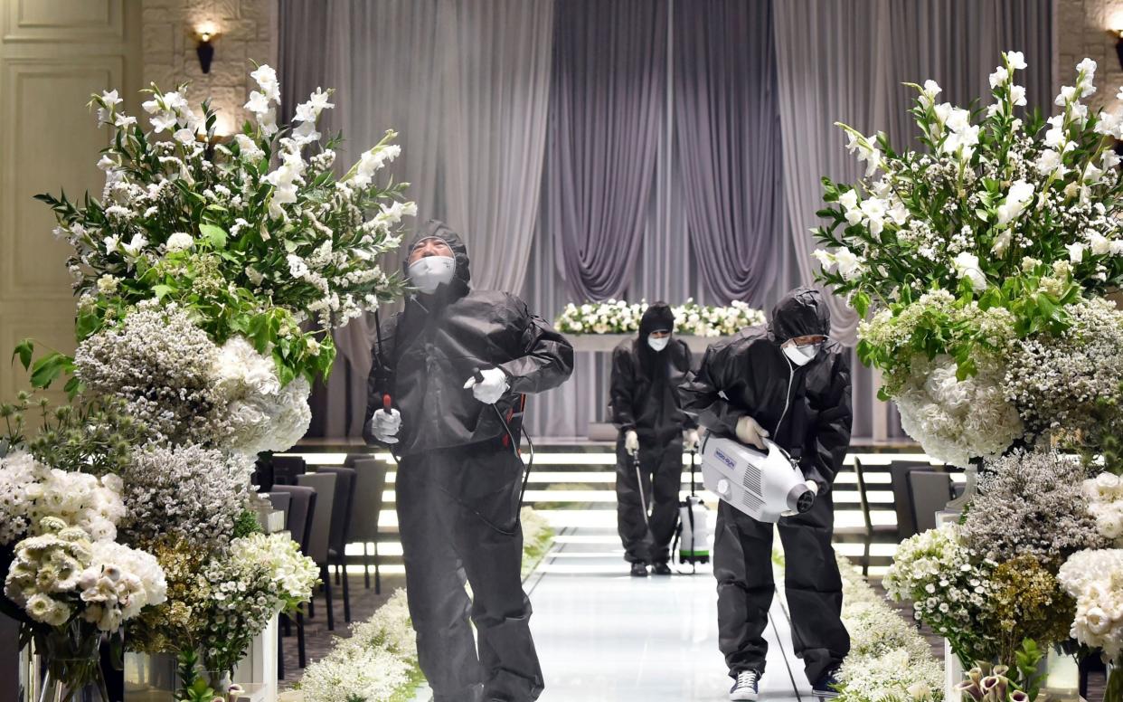 People wearing protective gear disinfect as a precaution against the new coronavirus at a wedding hall in Suwon, South Korea - Kim Jong-taik/NEWSIS