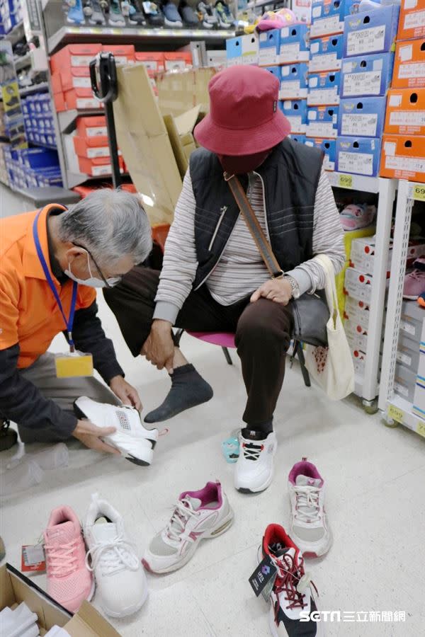 志工陪張阿嬤挑選鞋子，終於替阿嬤換了一雙新鞋。（圖／弘道臺中服務處提供）